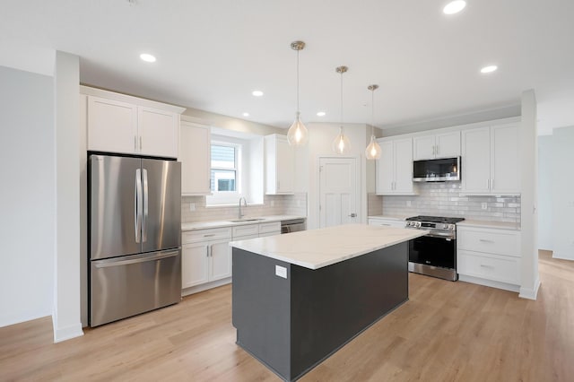 kitchen featuring backsplash, appliances with stainless steel finishes, a center island, and light wood-type flooring