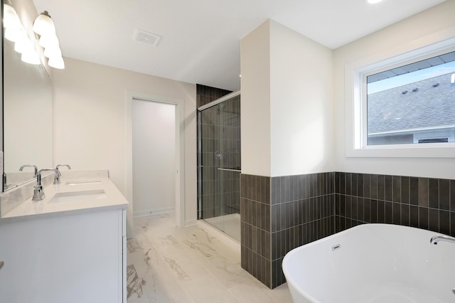 bathroom with separate shower and tub and double sink vanity