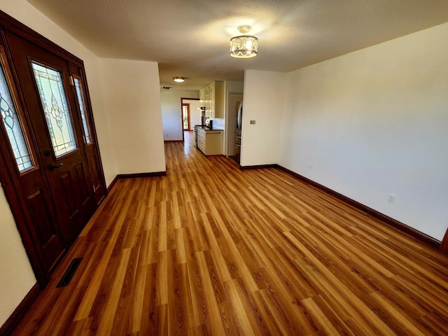 foyer featuring a textured ceiling and light wood-type flooring