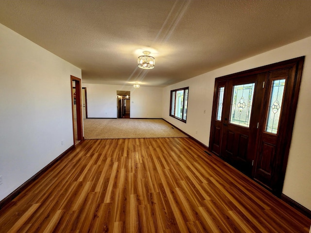 entrance foyer with a textured ceiling, hardwood / wood-style flooring, and a wealth of natural light