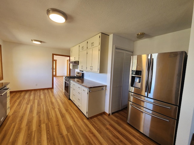 kitchen featuring white cabinetry, light hardwood / wood-style flooring, a textured ceiling, and appliances with stainless steel finishes