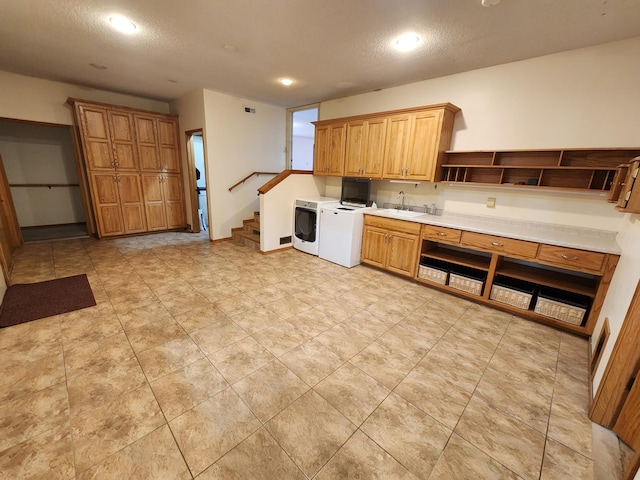 kitchen featuring washer and clothes dryer, a textured ceiling, and sink