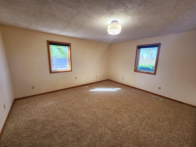 spare room featuring carpet and a textured ceiling