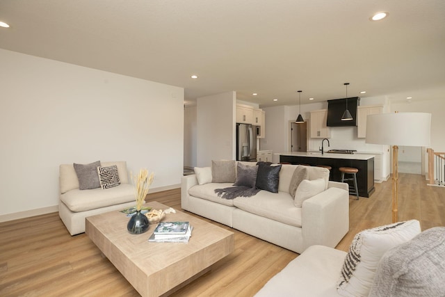 living room featuring light hardwood / wood-style floors and sink