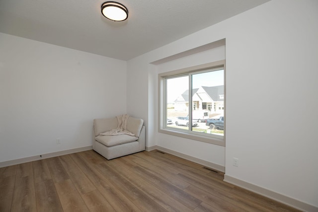 unfurnished room with a textured ceiling and light hardwood / wood-style floors