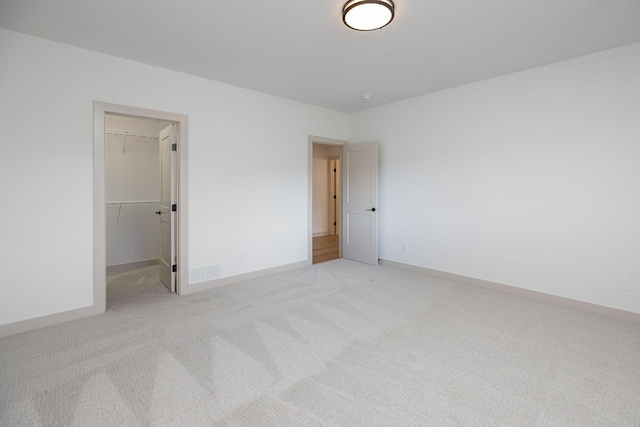 interior space with light colored carpet, a closet, and a spacious closet