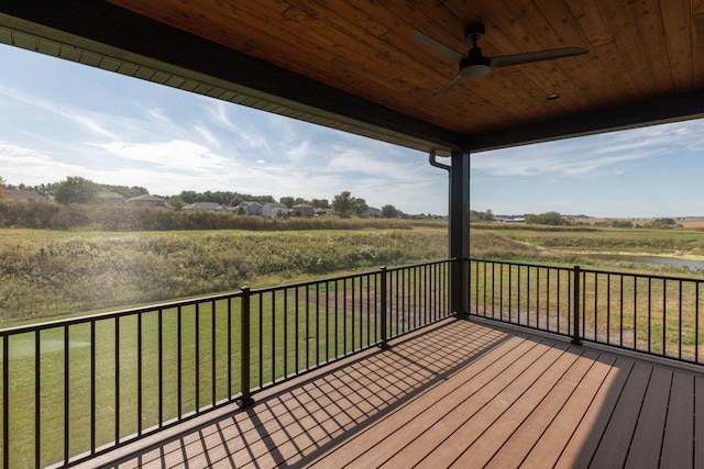 deck featuring ceiling fan, a rural view, and a lawn