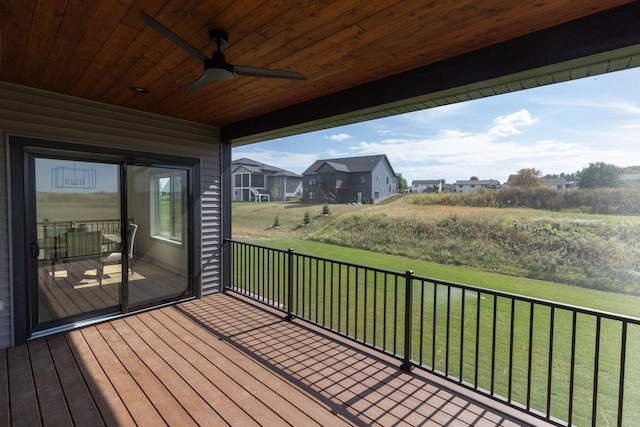 wooden deck featuring ceiling fan and a yard