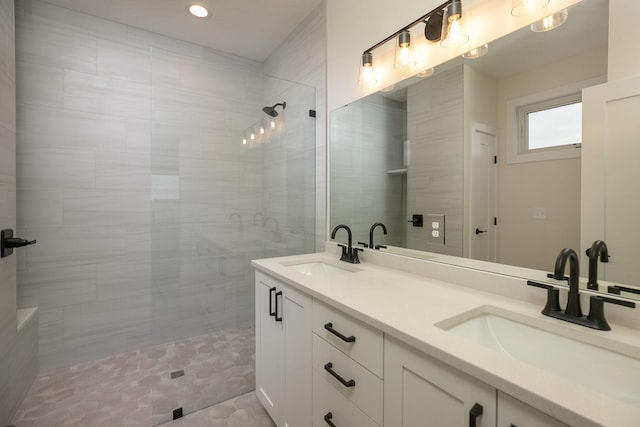 bathroom with vanity, a tile shower, and tile patterned flooring