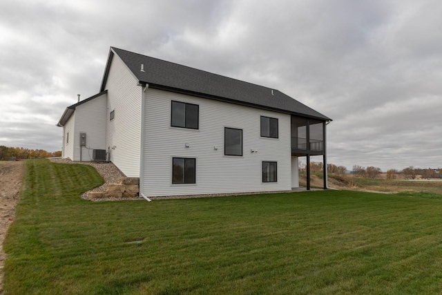 rear view of house with a yard and central air condition unit