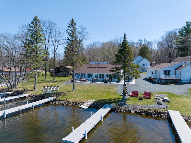 view of dock with a yard and a water view