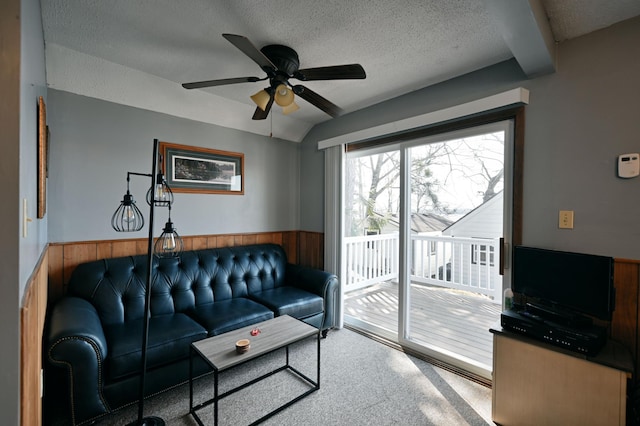 carpeted living room with a textured ceiling and ceiling fan