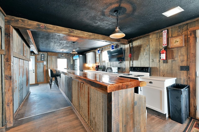 interior space with white cabinetry, wooden counters, decorative light fixtures, dark wood-type flooring, and white range with electric cooktop