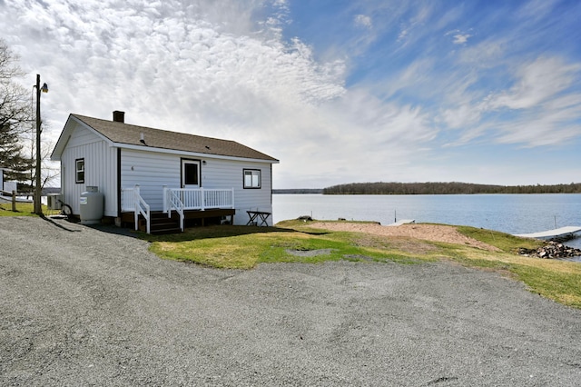 rear view of house featuring a deck with water view