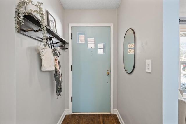 entryway featuring dark wood-type flooring and a textured ceiling