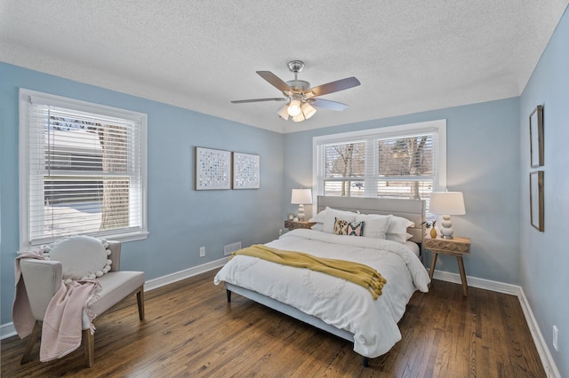 bedroom featuring dark wood-type flooring, multiple windows, and a textured ceiling