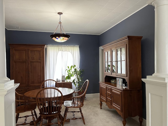 carpeted dining room with decorative columns and a wealth of natural light