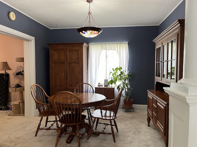 dining room featuring light colored carpet, ornate columns, and crown molding