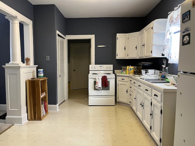 kitchen featuring white appliances, light tile flooring, white cabinetry, and ornate columns