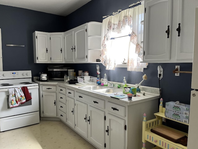 kitchen with white cabinets, sink, light tile floors, and electric stove