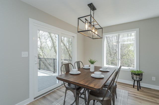 dining space with a notable chandelier and light hardwood / wood-style floors