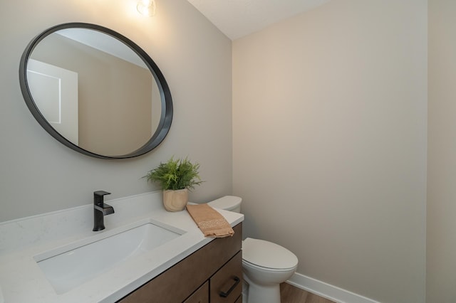 bathroom featuring vanity, wood-type flooring, and toilet