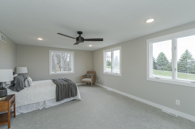 carpeted bedroom with ceiling fan and a textured ceiling