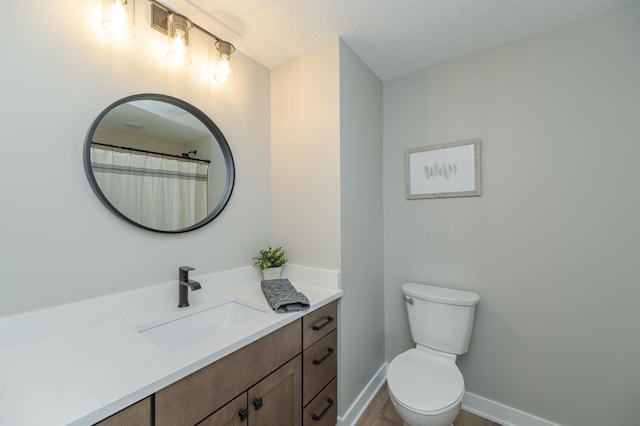 bathroom with vanity, a textured ceiling, and toilet