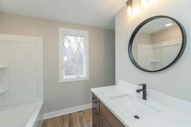 bathroom with vanity, hardwood / wood-style flooring, and shower / washtub combination