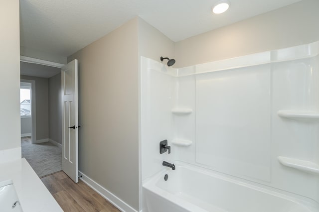 bathroom with wood-type flooring, vanity, a textured ceiling, and shower / bathing tub combination