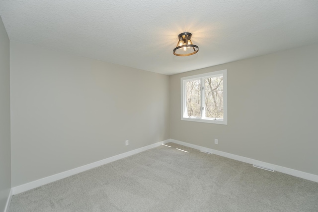 unfurnished room featuring light colored carpet and a textured ceiling