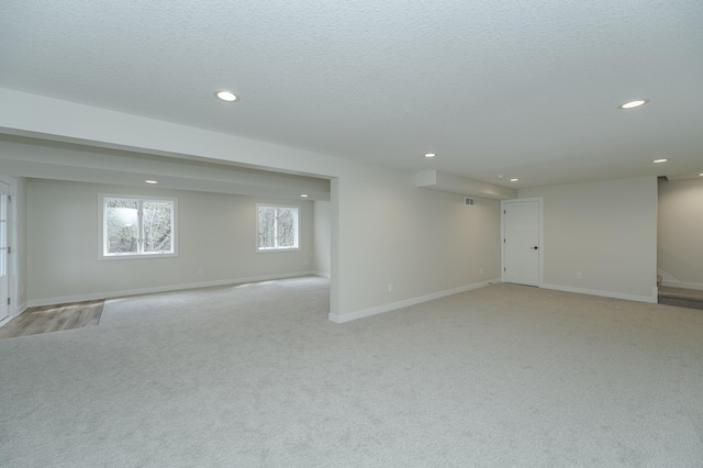 carpeted empty room featuring a textured ceiling