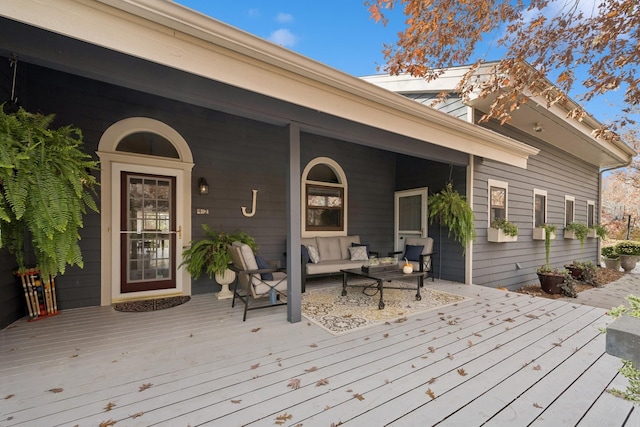 wooden terrace with an outdoor living space