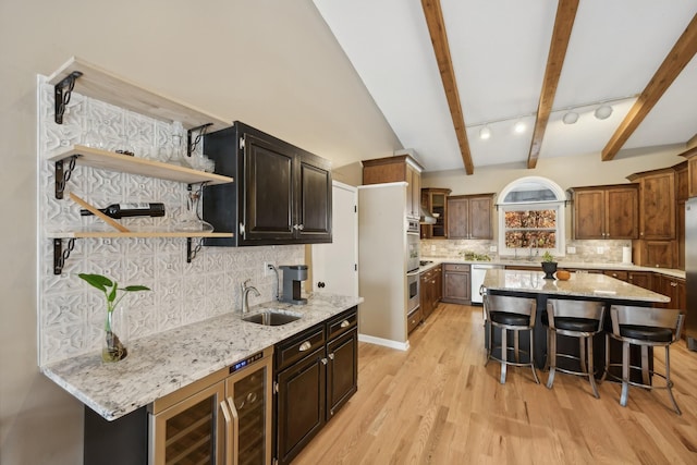 kitchen with sink, a kitchen island, backsplash, wine cooler, and a breakfast bar