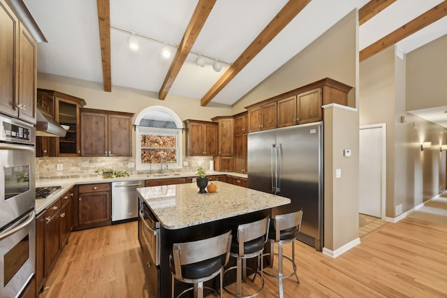 kitchen featuring light hardwood / wood-style floors, a center island, stainless steel appliances, and track lighting