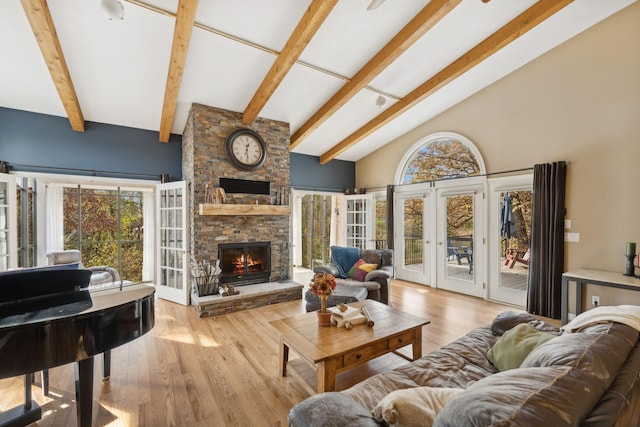 living room featuring beam ceiling, high vaulted ceiling, light hardwood / wood-style flooring, a fireplace, and french doors