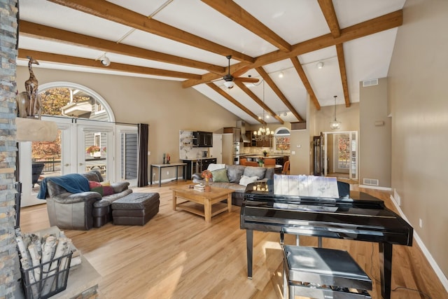 misc room featuring beam ceiling, high vaulted ceiling, light wood-type flooring, and ceiling fan with notable chandelier