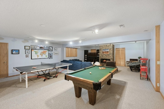 rec room with track lighting, pool table, a fireplace, carpet floors, and a textured ceiling