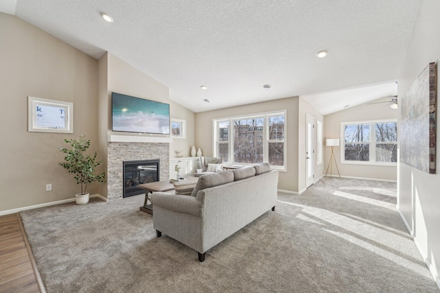 living room featuring a fireplace, a textured ceiling, vaulted ceiling, and plenty of natural light