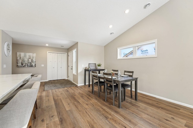 dining space featuring lofted ceiling and light wood-type flooring