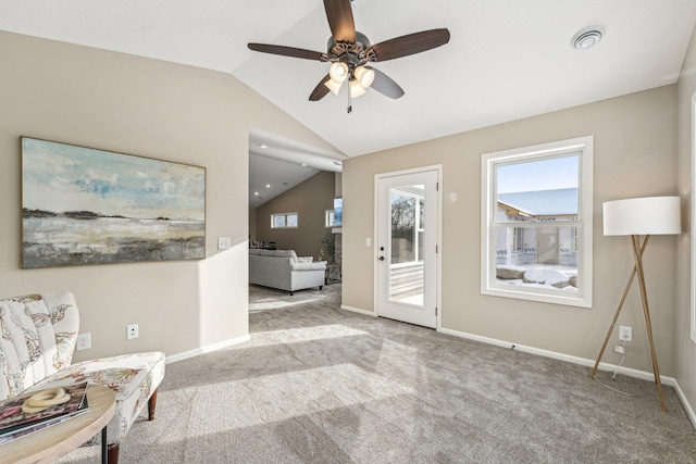 carpeted foyer entrance with ceiling fan and vaulted ceiling