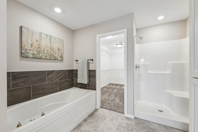 bathroom with a textured ceiling and a tub