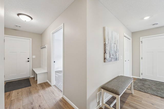 entrance foyer featuring a textured ceiling and light hardwood / wood-style flooring