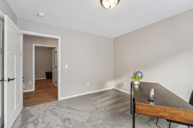 home office featuring carpet and a textured ceiling