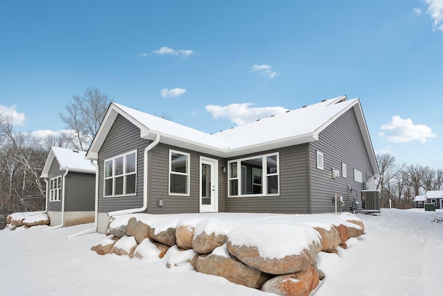 snow covered property with central AC unit