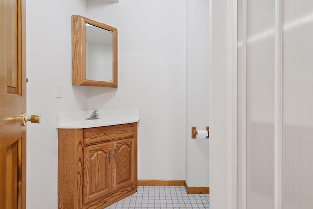 bathroom with vanity, baseboards, and tile patterned floors