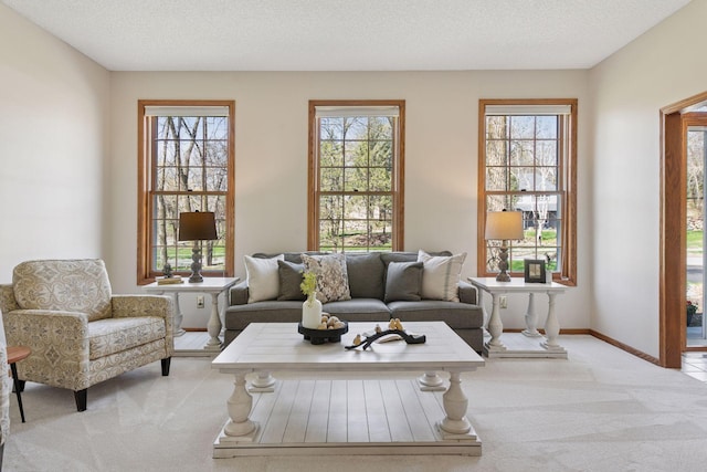living area featuring light colored carpet and baseboards