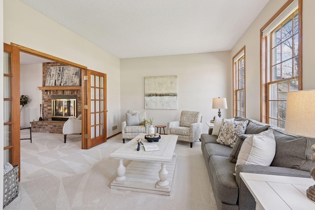 carpeted living room featuring french doors and a fireplace