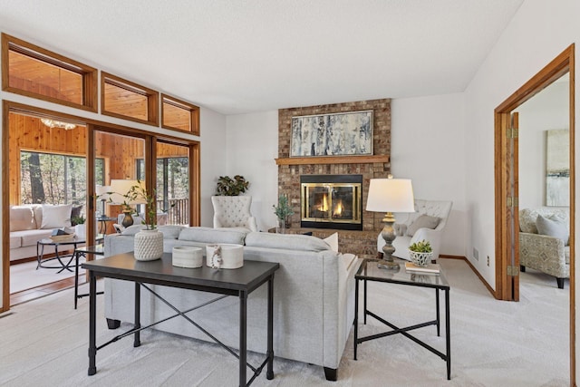 living room featuring baseboards, a fireplace, and light colored carpet