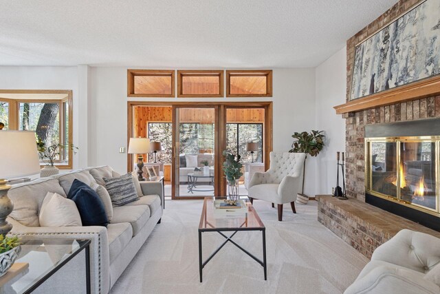living area with light colored carpet, a textured ceiling, a healthy amount of sunlight, and a fireplace